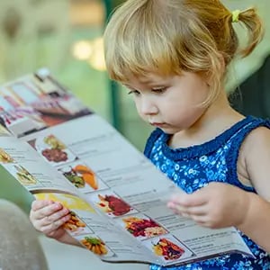 girl reading paper menu